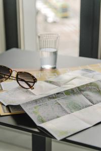 una mesa con un mapa y un par de gafas en Centro Design Apartments - Półwiejska, en Poznan