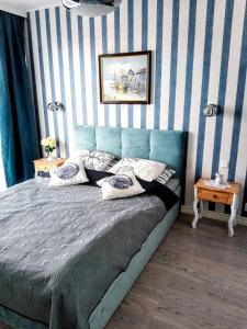 a bedroom with a bed with blue and white stripes at Horyzont 411 in Międzyzdroje