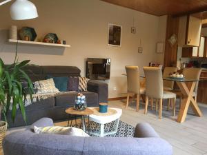 a living room with a couch and a table at Un petit coin d’Alsace in Soultzmatt