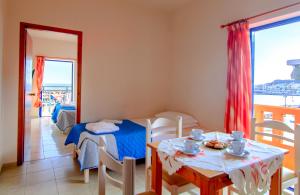 Scorpios Family Rooms في باليوخورا: غرفة معيشة مع طاولة وغرفة طعام