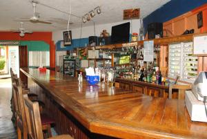 a large wooden bar in a restaurant with a lot of alcohol at Bluefields on the Bay in Good Hope