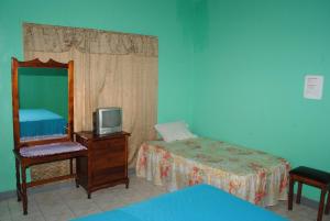 a bedroom with a bed and a mirror and a tv at Bluefields on the Bay in Good Hope