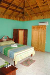 a bedroom with a bed and a wooden ceiling at Bluefields on the Bay in Good Hope