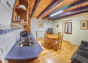 a kitchen with a sink and a table with chairs at Casa Rural Lenco in Cilveti