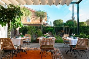 a patio with tables and chairs in front of a house at Hotel Boutique San Diego - Adults Only in Las Lagunas