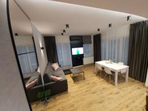 Televízia a/alebo spoločenská miestnosť v ubytovaní DOBRY MOMENT - apartament Giżycko