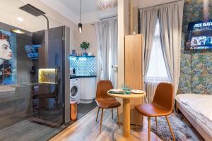 een kleine kamer met een tafel en stoelen en een bed bij ECONOMY downtown design apartments - FREE PARKING - balcony - super puplic transport - AC in Boedapest