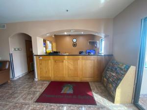 a living room with a couch and a kitchen at Tropicana Inn and Suites in Oldham