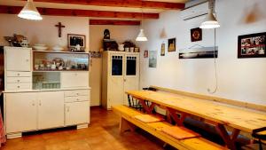 a dining room with a wooden table and a bench at Apartments Grbin in Ližnjan