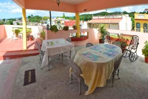 a patio with two tables and chairs on a balcony at Hostal Alcuria in Trinidad