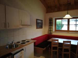 a kitchen with a sink and a table with chairs at Scheffauerhof in Scheffau am Wilden Kaiser