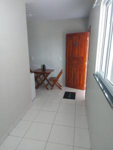 a hallway with a wooden door and a table and a window at Pôr do sol apartamentos in Fortaleza