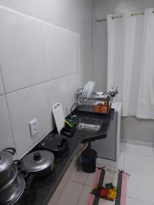 uma cozinha com um lavatório e uma bancada em Pôr do sol apartamentos em Fortaleza
