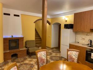 a kitchen with a table and a kitchen with a fireplace at Brīvdienu māja Kaļviļumi in Vietalva +43 photos