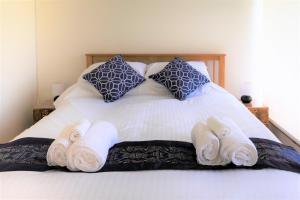 a bed with towels and pillows on it at Jopes Mill and Lodge in Looe +28 photos