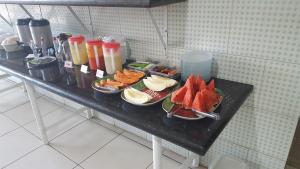 una mesa con tres platos de comida. en Yves Hotel, en Porto Velho