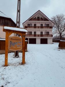 un panneau dans la neige devant une maison dans l'établissement Popas in Breb, à Breb