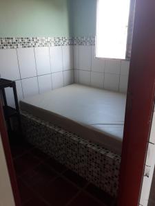 a small room with a bed in a bathroom at Apartamento Morada do Sol in Ilha Comprida