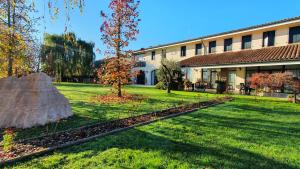 - un bâtiment avec une cour agrémentée d'un arbre et d'un rocher dans l'établissement Agriturismo il Cascinale, à Trévise