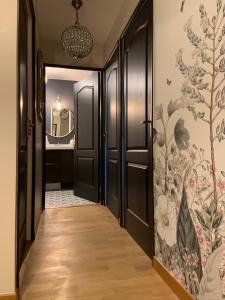 un pasillo con puertas negras y papel pintado con motivos florales en Luxury Appartement Disneyland en Magny-le-Hongre