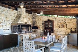 a kitchen with a table and a stone wall at Alea Resort Villas in Lefkada Town