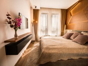 una habitación de hotel con una cama y un jarrón de flores en Apartman 23 - Vila Harizma en Zlatibor