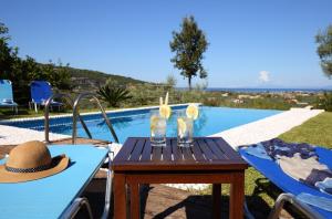 a table with a hat sitting next to a swimming pool at Alea Resort Villas in Lefkada Town