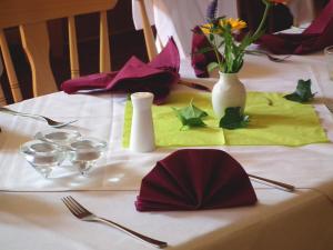 a table with a white table cloth with flowers on it at Gasthaus & Hotel Zur Linde in Friedrichroda