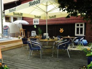 a patio with tables and chairs and an umbrella at Gasthaus & Hotel Zur Linde in Friedrichroda