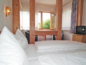 a bedroom with two beds and a desk and a window at Gasthaus & Hotel Zur Linde in Friedrichroda