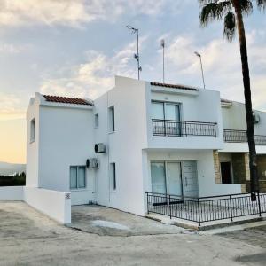 a white house with a palm tree in front of it at El Sueno in Lachi