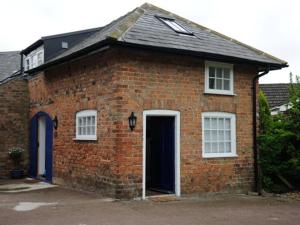 a red brick house with a door and windows at Apple Loft in Alford