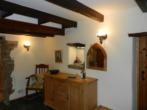 uma casa de banho com um toucador de madeira e um espelho. em Armidale Cottages B&B em Workington