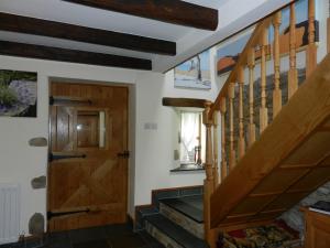 a hallway with stairs and a wooden door at Armidale Cottages B&B in Workington