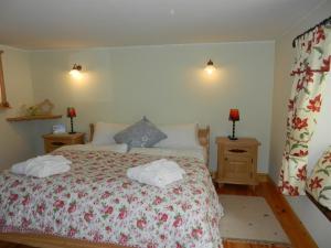 a bedroom with a bed with two towels on it at Armidale Cottages B&B in Workington