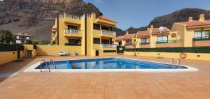 a house with a swimming pool in front of a building at Holiday in Playa Calera - Swimming pool in Valle Gran Rey