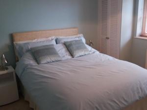 a bed with white sheets and pillows in a bedroom at Self Catering Stratford in Stratford-upon-Avon