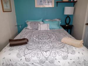 1 dormitorio azul con 1 cama con edredón blanco en Loft Estudio El Faro - Zona Estero Beach, en Ensenada