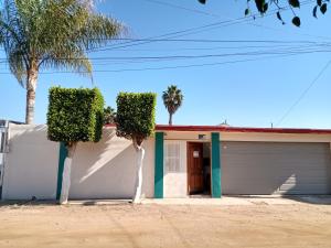 a house with palm trees in front of it at Loft Estudio El Faro - Zona Estero Beach in Ensenada