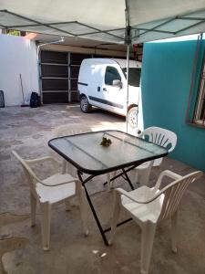 una mesa con sillas y una furgoneta blanca en un garaje en Loft Estudio El Faro - Zona Estero Beach, en Ensenada