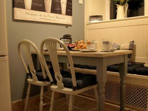 a table with a plate of food and two chairs at Plum Tree Cottage in Witton le Wear