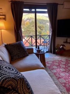 a room with two beds and a large window at Cozy mountain apartment in Platres in Platres