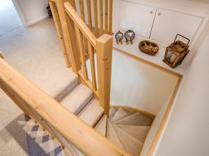 uma vista superior de uma escada com um corrimão de madeira em Chatton Cottage em Chatton