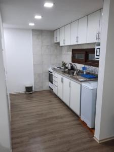 una cucina con mobili bianchi e pavimento in legno di La Encantada a Potrero de los Funes