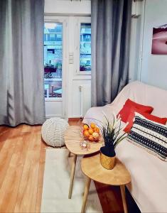 Cosy Appart Hotel Boulogne -Paris في بولون بيانكور: غرفة معيشة بها أريكة بيضاء وطاولة عليها فاكهة