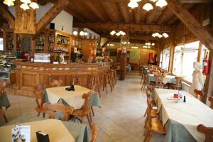 a restaurant with tables and chairs and a bar at Albergo Rendola in Asiago