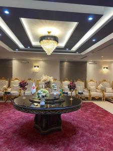 una grande stanza con un grande tavolo e sedie di Jazan Inn Hotel a Jazan