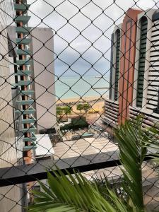 uma vista para uma cidade através de uma cerca de arame em Via Venetto Apt 1302 Meireles Fortaleza em Fortaleza