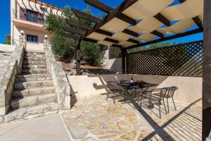 a patio with a table and chairs under a pergola at Villa Alexey Homeleader in Tavronitis