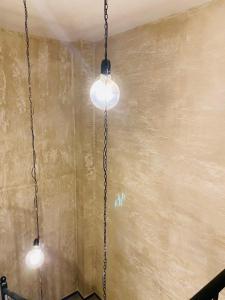 two lights hanging from a chain in a room at Дунав билдингс in Pleven